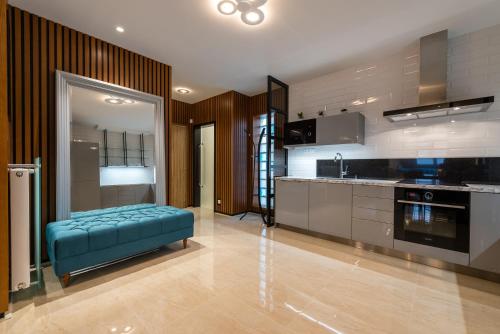 a kitchen with a blue ottoman in a room at Apartment on the Main Street with Parking Old Town in Košice