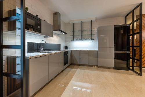 a kitchen with white cabinets and a black refrigerator at Apartment on the Main Street with Parking Old Town in Košice