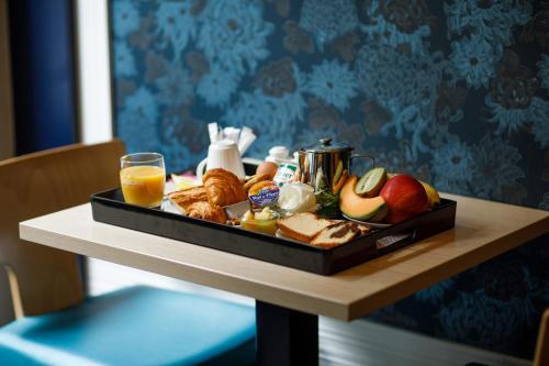 a tray of breakfast foods and orange juice on a table at Prince Albert Montmartre in Paris