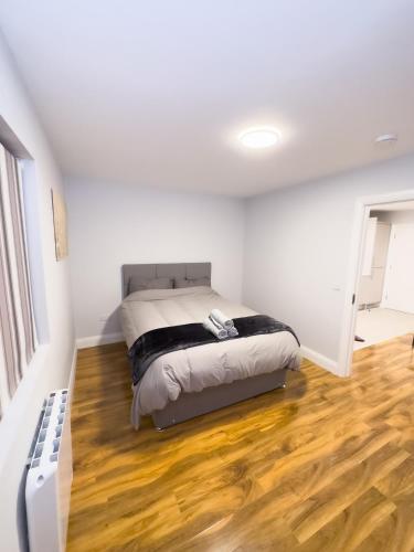 a bedroom with a bed and a wooden floor at Entire Cozy Guest house in Galway