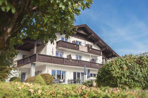 un grand bâtiment blanc avec un toit en bois dans l'établissement Anna Pertl - lieblingsquartier, à Sankt Gilgen