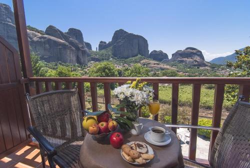 - une table avec des fruits et des légumes sur un balcon avec des rochers dans l'établissement Hotel Doupiani House, à Kalambaka