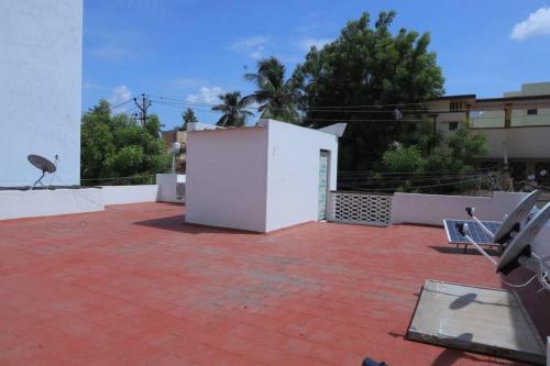 uma vista para um pátio com um edifício branco em Heritage home with 2 bed/2 bath with kitchen in a residential neighborhood. em Madurai