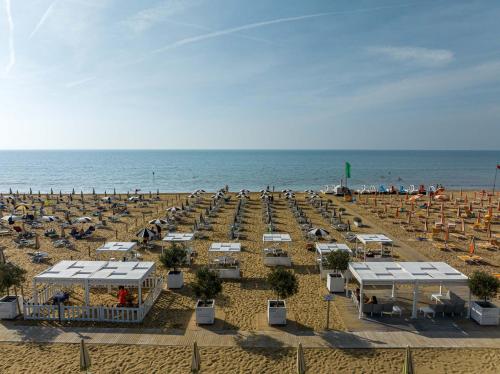 ein Strand mit vielen Stühlen und das Meer in der Unterkunft Hotel Las Vegas in Bibione