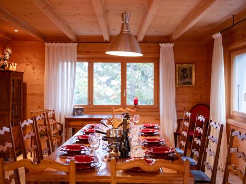 un comedor con una mesa con platos rojos. en Chalet Chalet Le Haut Pré by Interhome, en Villars-sur-Ollon