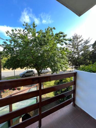 d'un balcon avec une clôture et un arbre. dans l'établissement Pinamar departamento, à Pinamar