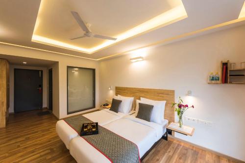 Super Townhouse MG Road,Bangalore في بانغالور: غرفة نوم بسرير كبير بسقف