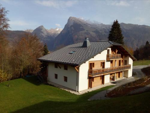 ein weißes Haus mit Bergen im Hintergrund in der Unterkunft Chalet d'Arfeuille - Chambre 2 personnes in Samoëns