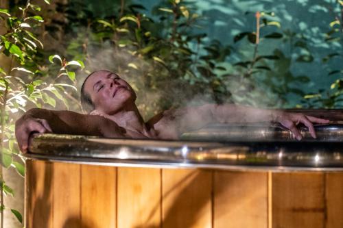 a man in a bathtub with steam coming out at Escale Rochelaise, chambre avec acces toute l'année au sauna et SPA chauffée in La Rochelle