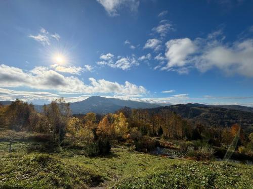 uma vista para as montanhas com o sol no céu em Michałówka na Kubalowej Łące em Szczyrk