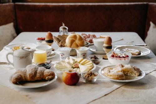 una mesa cubierta con platos de comida y repostería en Hotel Pradell, en Ortisei