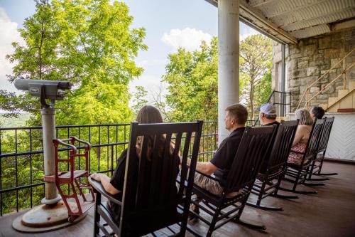 een groep mensen die in schommelstoelen op een veranda zitten bij 1886 Crescent Hotel and Spa in Eureka Springs