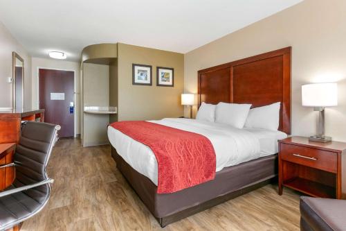 ein Hotelzimmer mit einem großen Bett und einem Stuhl in der Unterkunft Comfort Inn & Suites Van Buren - Fort Smith in Van Buren