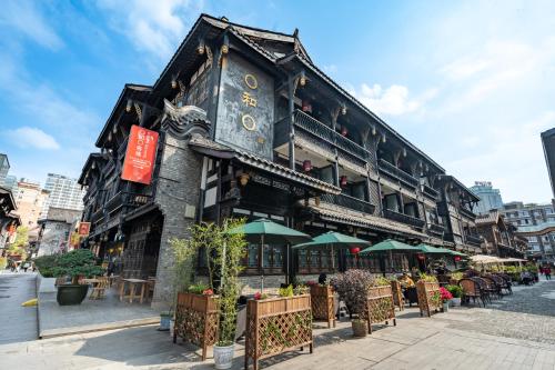 un edificio con tavoli e ombrelloni su una strada di Buddha Zen Hotel a Chengdu