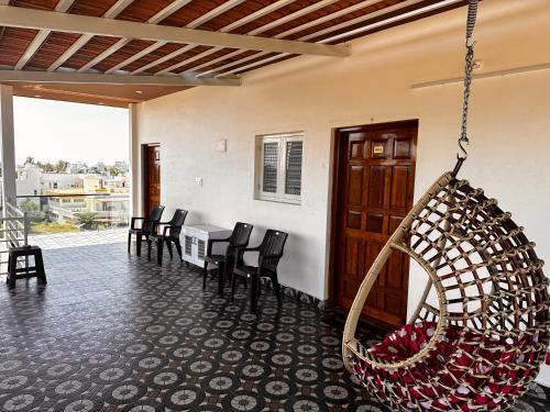 una camera con portico con sedie e altalena di DEEYA Guest House - A Luxury Home Stay a Mysore