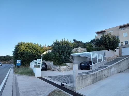 a parking lot with two cars parked next to a building at Apartmani NIKA in Dubrovnik