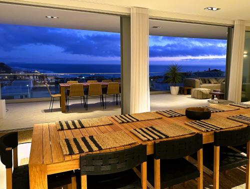 ein Esszimmer mit einem Tisch und Meerblick in der Unterkunft Villa Surf Vista - Praia da Areia Branca in Lourinhã