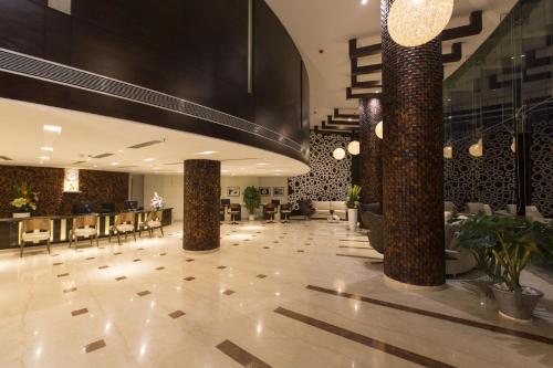 a lobby of a hotel with tables and chairs at The President Hotel in Hubli