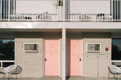 two pink doors on the side of a building at The June Motel, Prince Edward County in Picton