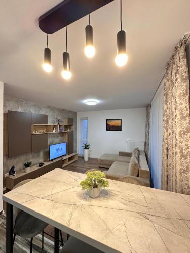 een woonkamer met een tafel en een bank bij Deluxe Cozy Apartments - Coresi Mall #Brasov in Braşov