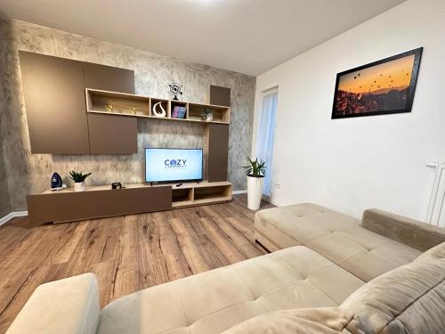 een woonkamer met een bank en een flatscreen-tv bij Deluxe Cozy Apartments - Coresi Mall #Brasov in Braşov