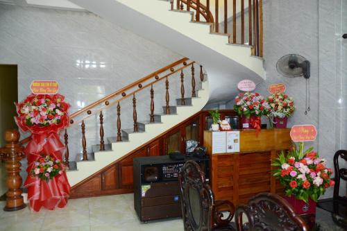 una sala de estar con una escalera con flores. en Hoang Ngoc Motel, en Lang Co