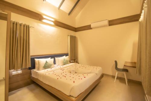 sypialnia z łóżkiem i krzesłem w obiekcie SaffronStays Eden, Nashik - pet-friendly villa with pool, jacuzzi & grape farm w mieście Nashik