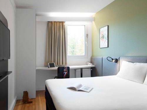 een hotelkamer met een bed met een boek erop bij ibis Nancy-Brabois in Vandoeuvre-lès-Nancy