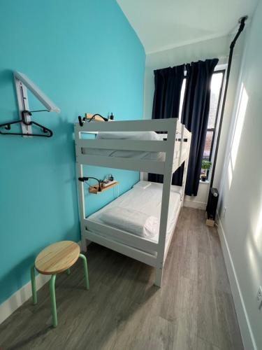 a bunk bed in a room with a table and a stool at East Harlem Hostel in New York