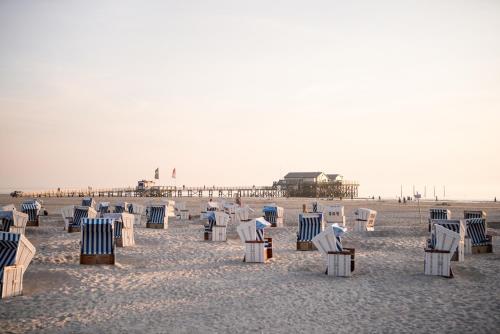 un gruppo di sedie su una spiaggia con molo di Beach Motel St. Peter-Ording a Sankt Peter-Ording