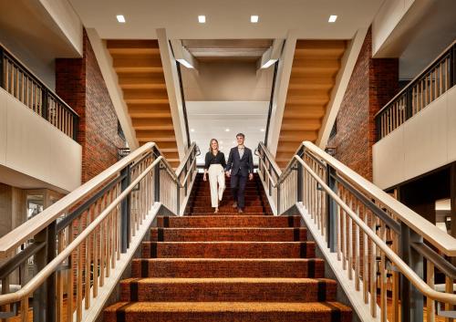 Ein Mann und eine Frau gehen die Treppe hinunter in der Unterkunft The Charles Hotel in Harvard Square in Cambridge