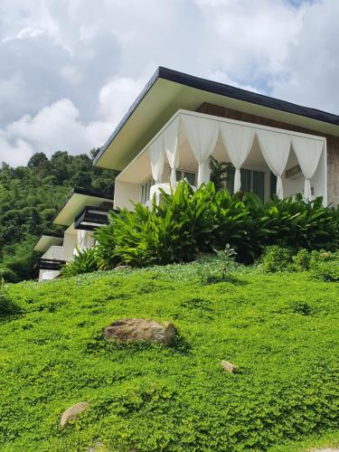 ein Haus auf einem Grashügel in der Unterkunft เฌอปือ เชียงใหม่ Cherpue Chiangmai 