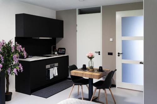 Il comprend une cuisine équipée d'une table, de chaises et d'une cuisinière. dans l'établissement Luxury room with king size bed, à Dordrecht