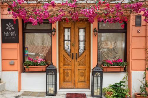 una casa naranja con una puerta de madera y flores en Sweet Home Hotel, en Atenas