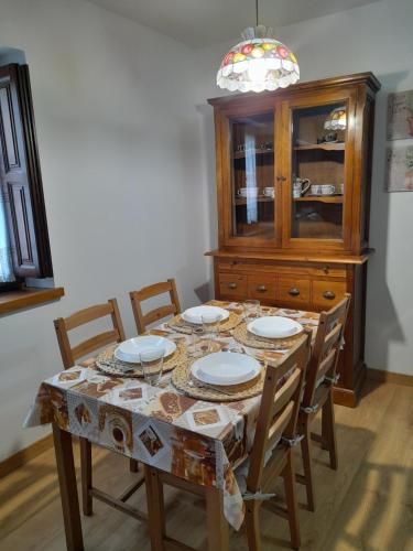 une table à manger avec des chaises et une armoire en porcelaine dans l'établissement Casa del Horno, à Potes