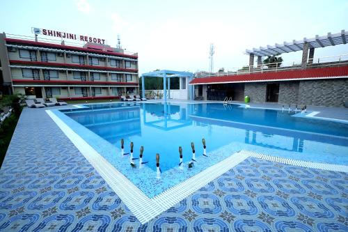 una piscina con anatre al centro di un edificio di Shinjini Resort a Mandarmoni