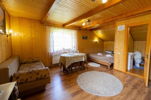 - une chambre avec un lit et une table dans l'établissement Садиба У Василини та Романа, à Bukovel