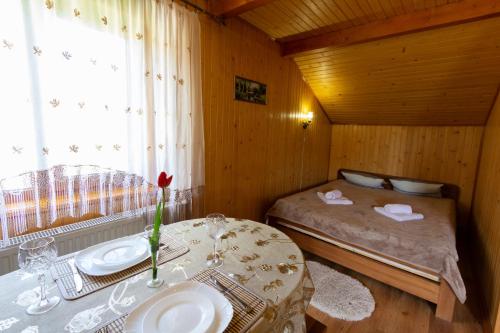 Cette petite chambre comprend un lit et une table avec un lavabo. dans l'établissement Садиба У Василини та Романа, à Bukovel