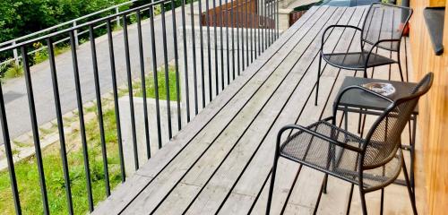 une terrasse en bois avec deux chaises et une clôture dans l'établissement Harrachov 702, à Harrachov