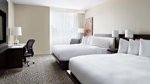 um quarto de hotel com duas camas e uma secretária e uma televisão em Pittsburgh Marriott North em Cranberry Township