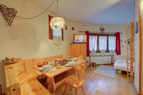 a dining room with a wooden table and chairs at Studio Grange Nest Ski & Relax - Happy Rentals in Sestriere