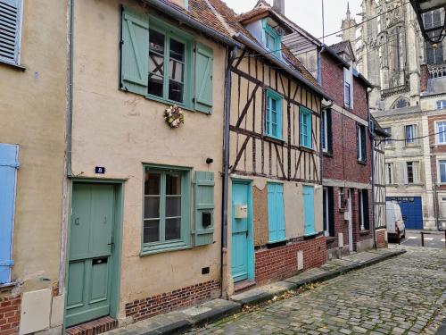 ein altes Gebäude mit blauen Türen und Fenstern auf einer Straße in der Unterkunft LA PETITE BEAUVAISIENNE in Beauvais