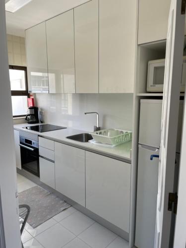 cocina blanca con fregadero y microondas en Appartement, praia da rocha, PORTIMAO, en Portimão