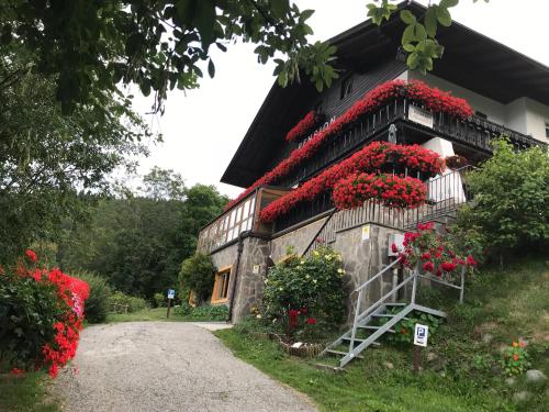 um edifício com flores vermelhas ao lado em Alpenblick Bed & Breakfast em Vipiteno