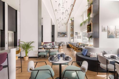 een restaurant met tafels en stoelen en een plafond bij YOTEL Porto in Porto