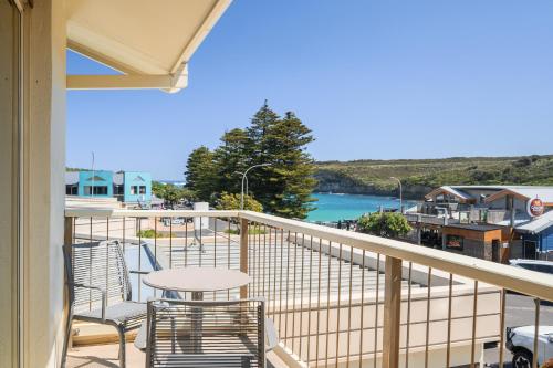 balcone con sedie, tavolo e vista sull'acqua di Loch Ard Motor Inn a Port Campbell