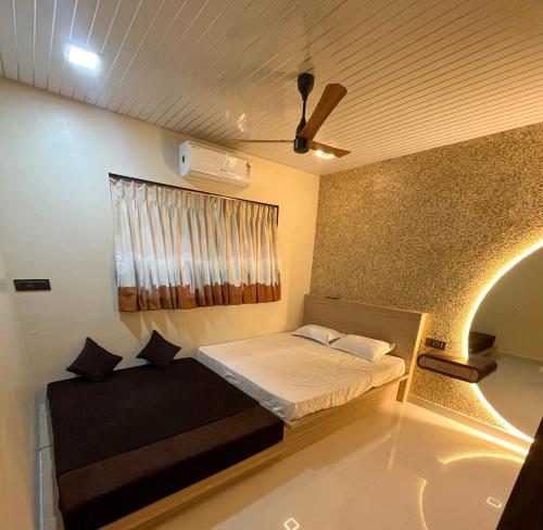 1 dormitorio pequeño con 1 cama y ventilador de techo en Cloud9 Villa (Yeoor Hills, Thane) - A Luxurious Private Jungle Villa., en Thane