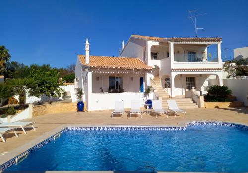 una villa con piscina di fronte a una casa di Vila Lana - Heated pool - Sea view - Two independent floors a Faro