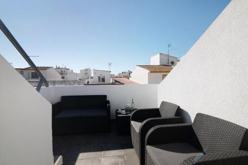 - un balcon avec deux chaises et une table dans un bâtiment dans l'établissement Be Glow Home, à Alvor