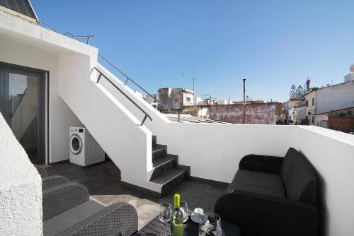 Elle comprend un balcon avec une chaise et un escalier. dans l'établissement Be Glow Home, à Alvor